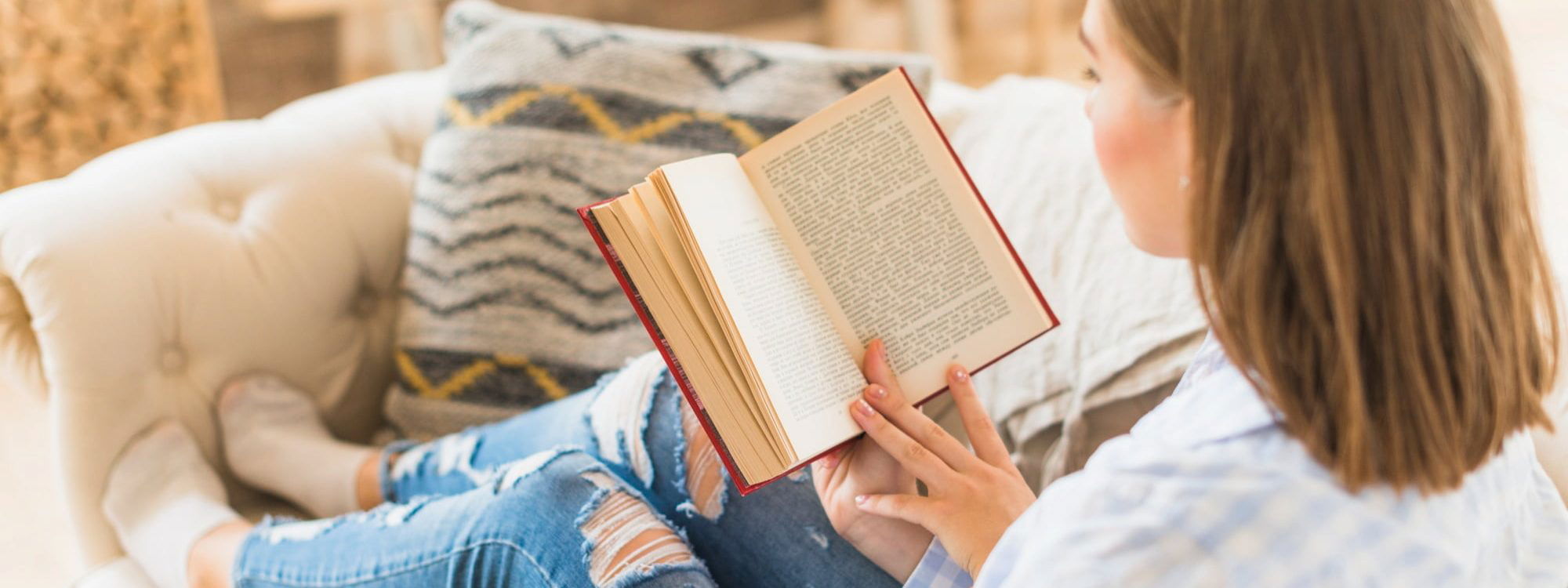 Woman reading a book on sofa
