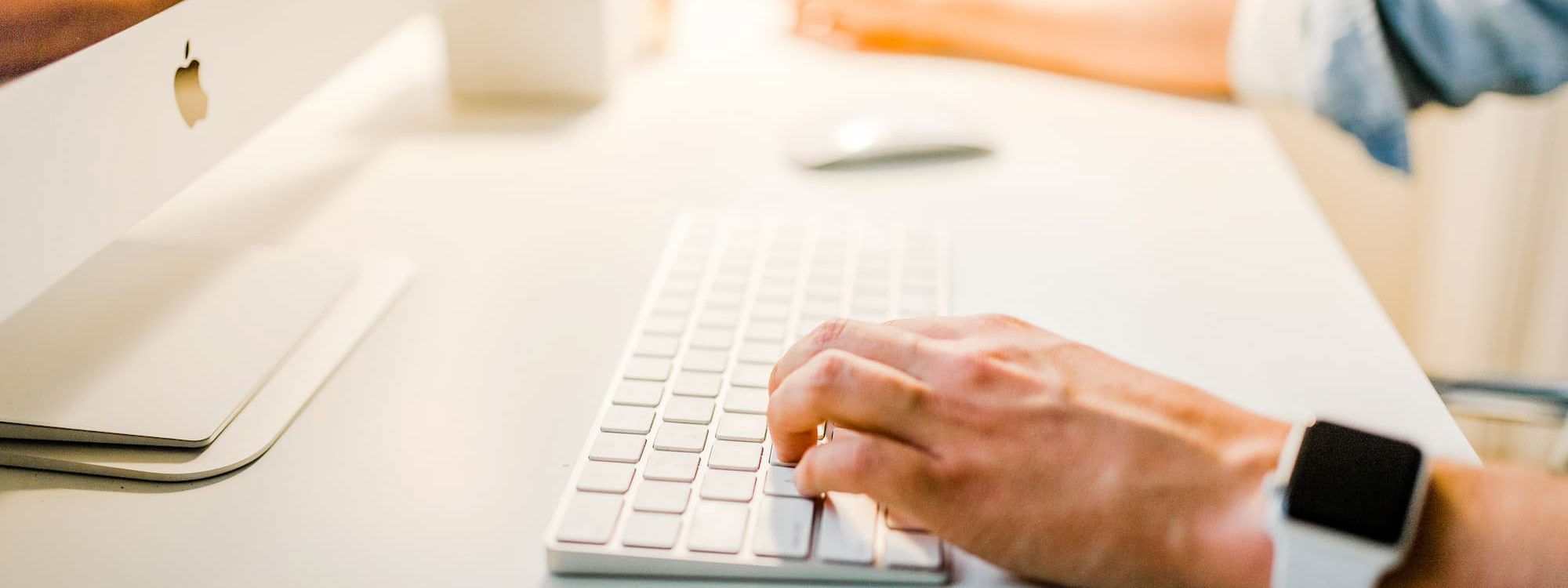 Person sat at desk with iMac