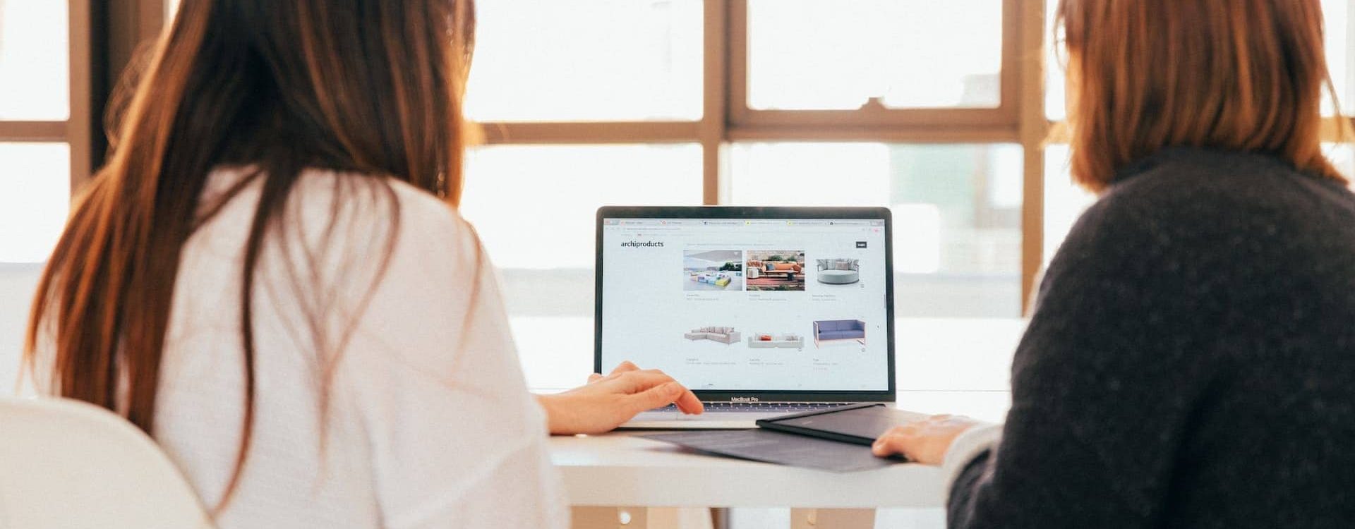 Two women looking at website on a laptop