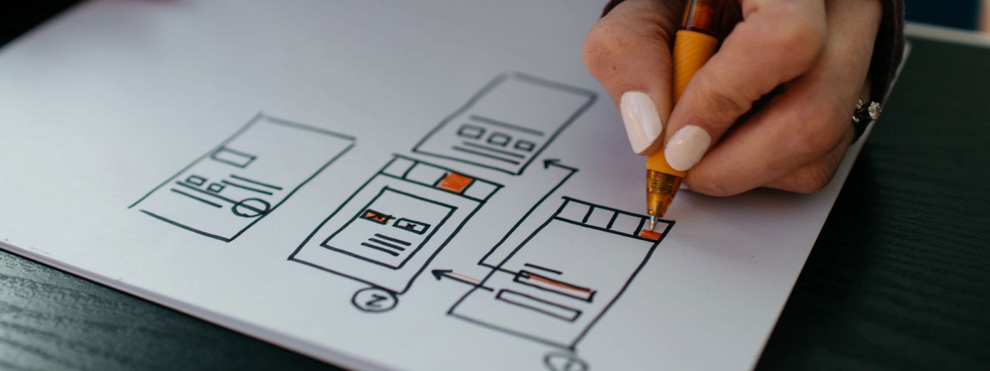 Designer drawing wireframe on paper